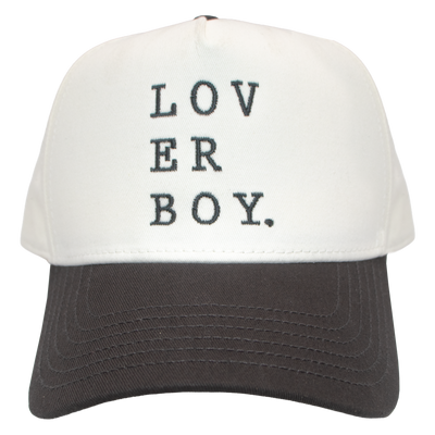 Natural five-panel hat with charcoal brim and pink button, featuring "LOV ER BOY." embroidered in dark gray serif lettering stacked across three lines on the crown.
