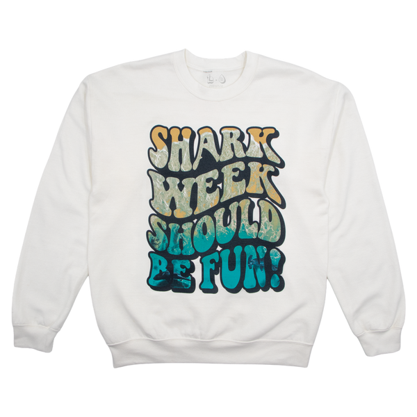 A white crewneck sweatshirt featuring a large, colorful retro-style graphic on the front that reads 'SHARK WEEK SHOULD BE FUN!' in wavy, bubbly letters with a distressed texture.