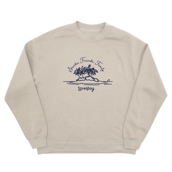 A light cream crewneck sweatshirt featuring a navy navy graphic of a small tropical island with palm trees, a shark fin, and the text 'Sharks, Friends, Fish' and 'Loverboy'.